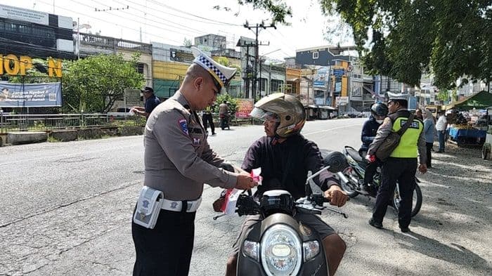 jelang_hut_ri_ke80_polsek_kualuhhulu_bagikan_200_bendera_merah_putih_kepada_pengendara