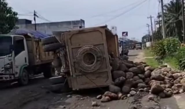 truk_batu_koral_terbalik_di_galang_warga_keluhkan_jalan_rusak_bertahuntahun_