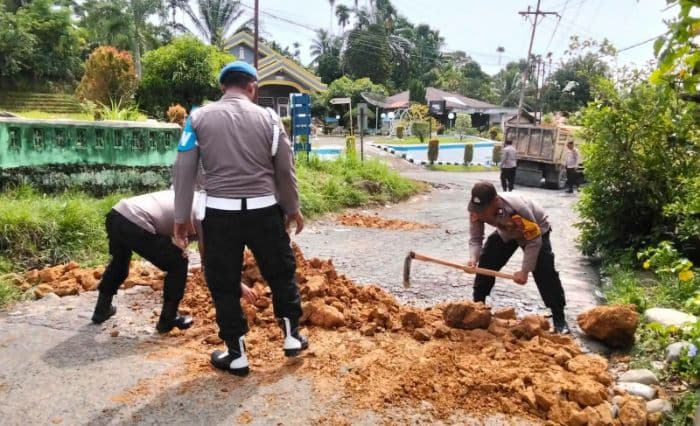 polisi_dan_warga_timbun_jalan_rusak_berlubang_di_jalur_menuju_bukit_lawang