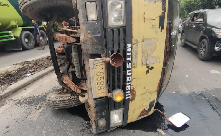 hantam_pembatas_jalan_truk_muatan_barang_bekas_terbalik_di_sunggal