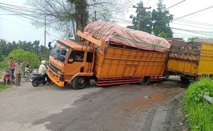 dua_truk_tbs_terperosok_di_jalan_rusak_binjai_selatan_akses_sempat_terputus