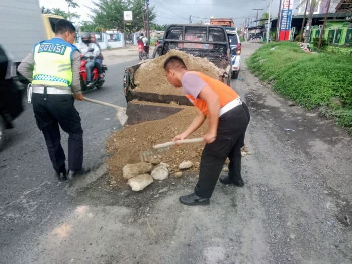 satlantas_polres_batu_bara_timbun_lubang_menganga_di_jalinsum_km_100101