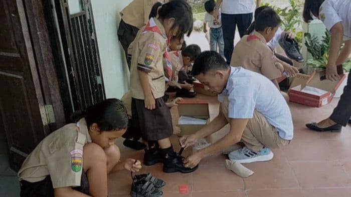 mian_fidelis_malau_salurkan_bantuan_sepatu_untuk_siswa_sd_negeri_23_dosroha_samosir