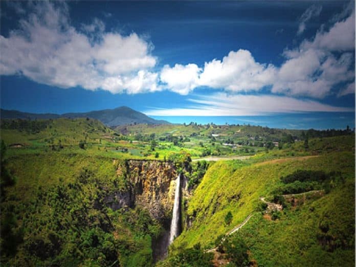 air_terjun_sipiso_piso_di_karo_keluar_dari_goa