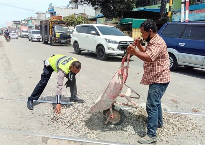 antisipasi_kemacetan_sat_lantas_polres_batu_bara_timbun_jalan_berlubang_di_perlintasan_ka