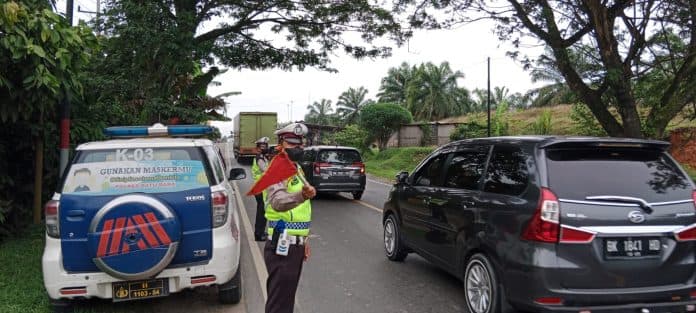 cegah_lakalantas_polres_batu_bara_kibas_bendera_di_titik_rawan