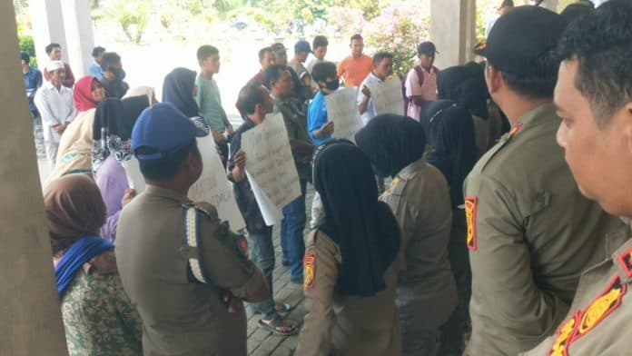 diduga_diberhentikan_sepihak_dan_menjadi_korban_pungli_perangkat_desa_dan_warga_demo_kantor_bupati_palas