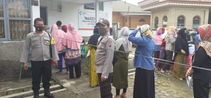 polsek_lima_puluh_pastikan_penerapan_prokes_bagi_penerima_bst