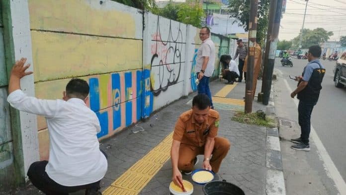 polsek_medan_baru_dan_kecamatan_bersihkan_corat_coret_di_depan_medan_plaza