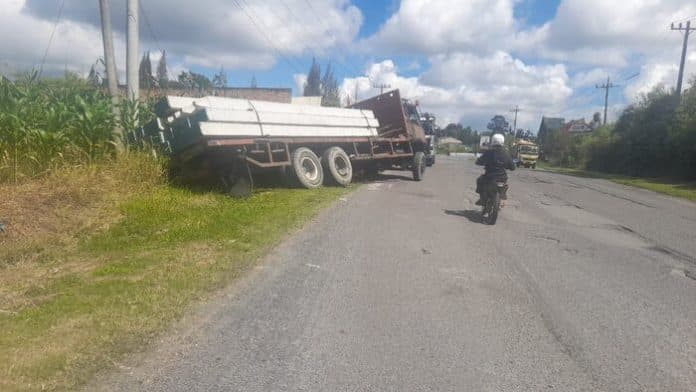 truk_bermuatan_paku_bumi_terperosok_ke_lahan_pertanian_warga_di_simalungun_sopir_hilang