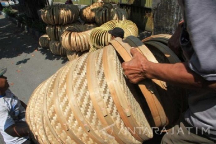 Pekerja menaikkan aneka produk kerajinan bambu berbentuk tampah, caping dan pengki ke atas truk jurusan Tulungagung-Surabaya di Tulungagung, Jawa Timur.ANTARA/Destyan Sujarwoko