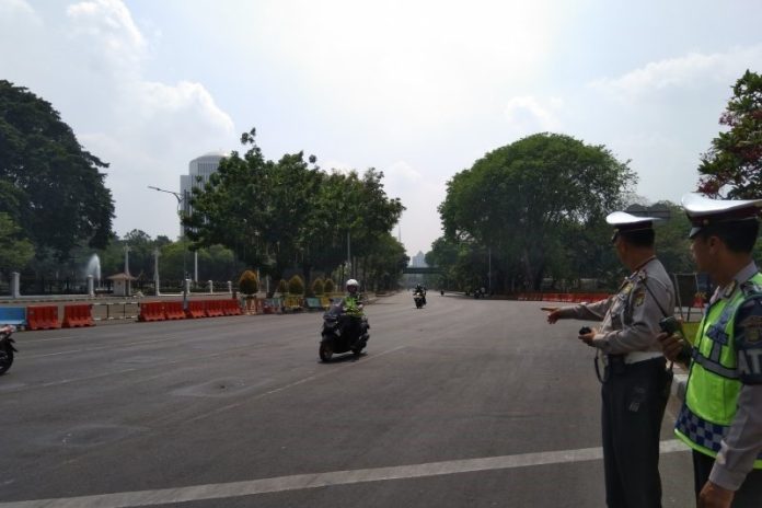 Petugas mengarahkan kendaraan yang melintas di Jalan Merdeka Utara depan Istana Negara saat penutupan jalan dilakukan, Senin (14/10/2019). (ANTARA/Laily Rahmawaty/Mistar)