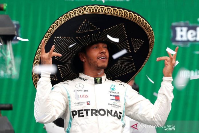 Pebalap Mercedes Lewis Hamilton melakukan selebrasi usai menjuarai Grand Prix Meksiko di Sirkuit Hermanos Rodriguez, Minggu waktu setempat. (27/10/2019) Reuters/Carlos Jasso
