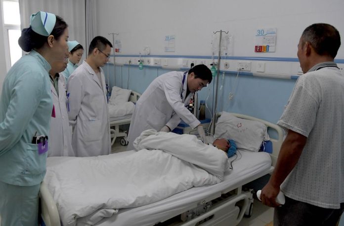 Staf medis memeriksa seorang pasien setelah pelaksanaan operasi di Rumah Sakit Penyakit Menular Henan yang terletak di Zhengzhou, ibu kota Provinsi Henan, China tengah, pada 31 Juli 2019. (Xinhua/Li An)