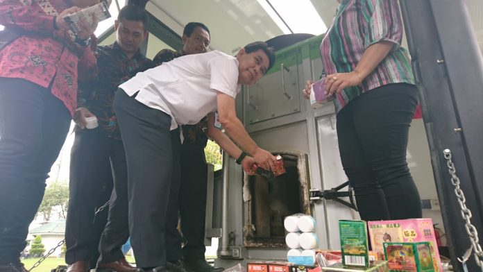 Plt Kepala BBPOM di Medan, Fajar Siddik sedang memusnahkan produk ilegal hasil sitaan selama tahun 2019, Jumat (20/12). (Foto mistar / saut)