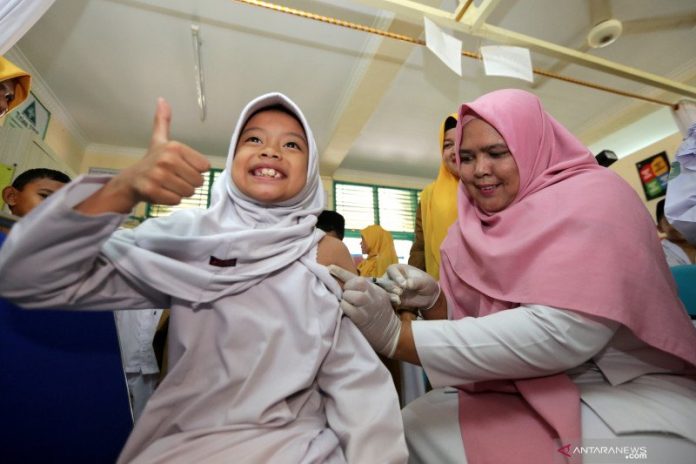 Petugas pusat kesehatan masyarakat (Puskesmas) Ulee Kareng (kanan) memberikan imunisasi vaksin difteri, campak rubella dan vaksin tetanus pada pelajar di Madrasah Ibtidaiyah Negeri (MIN) V, Banda Aceh, Aceh, Selasa (29/10/2019). Pemberian vaksin difteri, campak rubella dan vaksin tetanus pada pelajar dilakukan untuk mencegah para siswa terjangkit berbagai virus penyakit. ANTARA/Irwansyah Putra