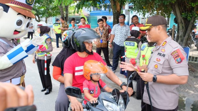 Kapolres Tanjungbalai AKBP Putu Yudha Prawira saat bercengkrama dan menyampaikan pesan-pesan keselamatan saat berkendaraan bagi pengendara roda dua. (f:ist/mistar)