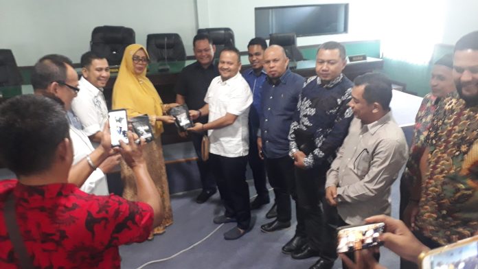 Ketua DPR Kabupaten Aceh Besar, Iskandar Ali menyerahkan kopi Aceh kepada Nurlela Sikumbang.(f:mistar/ferry napitupulu)