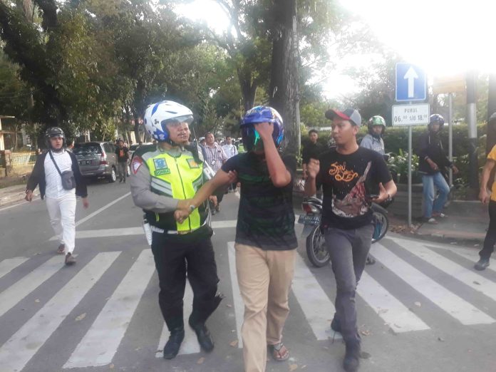 Seorang pelajar (tengah) yang terlibat tawuran di seputaran Taman Ahmad Yani Medan, saat diamankan oleh personil Sat Lantas Polrestabes Medan, Jumat (10/1). (Foto mistar / saut)