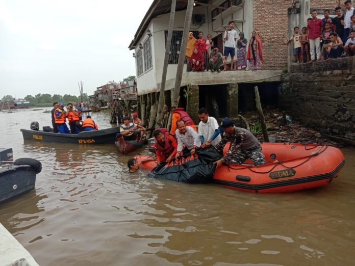 Petugas gabungan saat menemukan jasat Eko Gustian Sholeh Lie (13) yang hanyut saat terseret arus sungai. (IST)