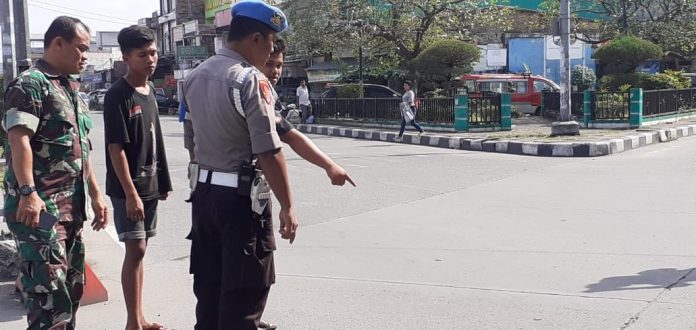 Personel Propam Polda Sumut dan TNI sedang meminta keterangan dari warga terkait anggota Ditsabhara Poldasu yang melompat dari Fly Over Jalan Djamin Ginting Medan, Kamis (30/1). (f:ist/mistar)