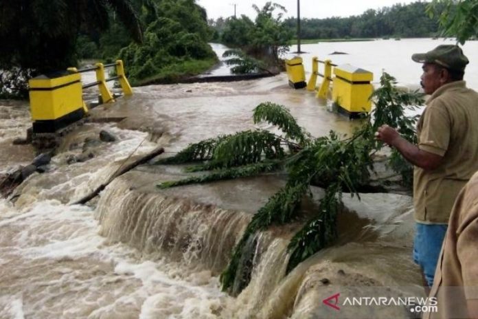 Ilustrasi - Salah seorang warga Cacang Randah, Nagari Tiku Utara, Kecamatan Tanjungmutiara, Kabupaten Agam, sedang melihat jalan yang amblas akibat meluapnya air Sungai Batang Tiku, Selasa (22/19). (ANTARA SUMBAR)