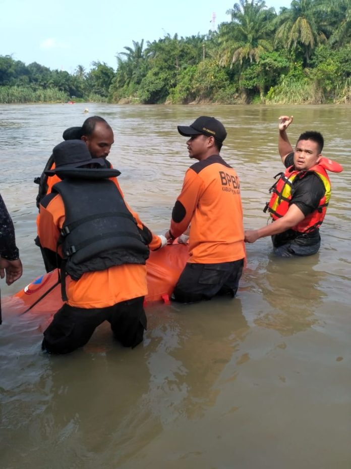 Tim pencari sedang mengavakuasi tubuh korban dari sungai. (f:azhar/mistar)