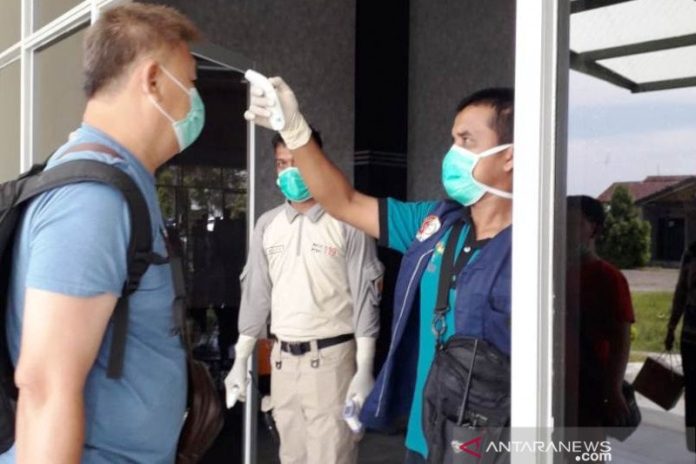 Petugas dari Dinas Kesehatan melakukan pemeriksaan suhu tubuh kepada penumpang yang baru tiba dari pesawat udara di Bandar Udara Cut Nyak Dhien Nagan Raya, Provinsi Aceh, Minggu (2/2/2020). ANTARA/HO-Dinas Kesehatan Pemkab Nagan Raya Aceh