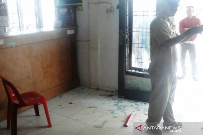Warga melintasi pecahan kaca dan kursi yang rusak di Kantor Camat Woyla Barat, Kabupaten Aceh Barat, setelah diamuk oleh sejumlah pelaku yang menolak prosesi pergantian jabatan kepala desa di kantor camat setempat, Senin (3/2/2010). (ANTARA/HO)