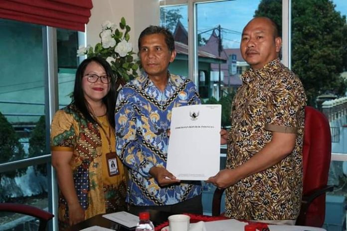 Bupati Taput Nikson Nababan menerima hasil survey Ombudsman dari kepala perwakilan Sumut, Abyadi Siregar. (f:ist/mistar)