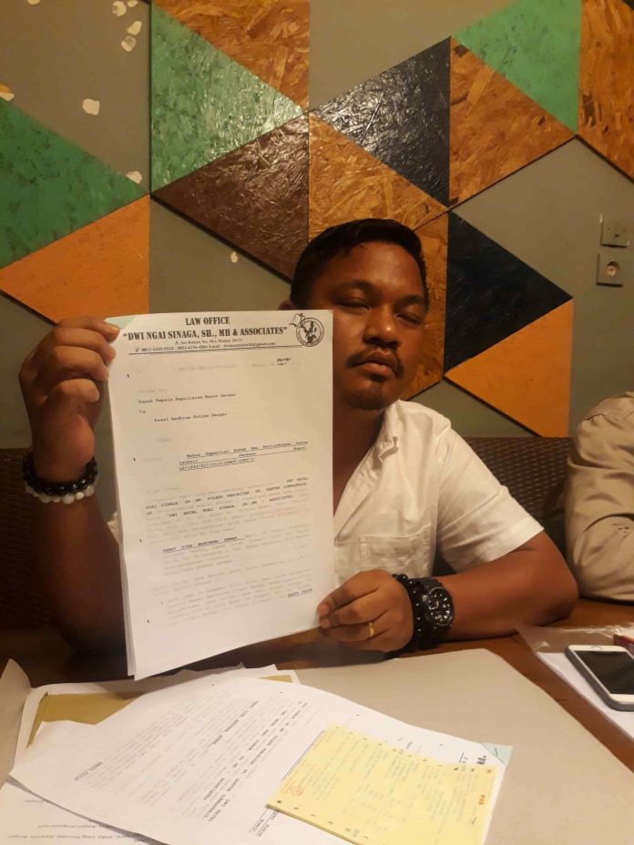 Kuasa hukum korban penganiayaan, Dwi Ngai Sinaga SH MH saat menunjukan surat laporan kliennya di Medan, Selasa (3/2). (F:mistar/saut)