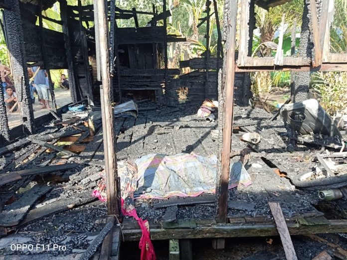 Bekas puing kebakaran rumah yang didiami Nenek Sofiah dengan jenazah korban yang gosong ditutupi sebelum dievakuasi. (f:ist/mistar)