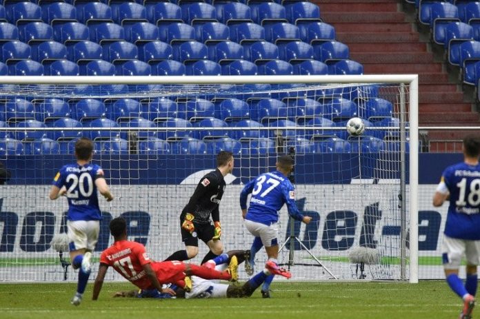 Gelandang Augsburg Noah Sarenren Bazee (kaus merah) mencetak gol kedua timnya pada pertandingan Liga Jerman melawan Schalke 04 yang dimainkan di Veltins Arena, Gelsenkirchen, Minggu (24/4/2020). (ANTARA/AFP/MARTIN MEISSNER)