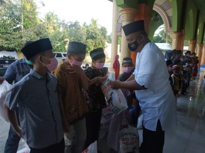 Direktur PT Galang Solusi Tehnik (GST) Sawaluddin Toelle menyerahkan bantuan 1 ton beras kepada anak yatim di Desa Kubah Sentang Kecamatan Pantai Labu Kabupaten Deli Serdang, Minggu (9/5/21).