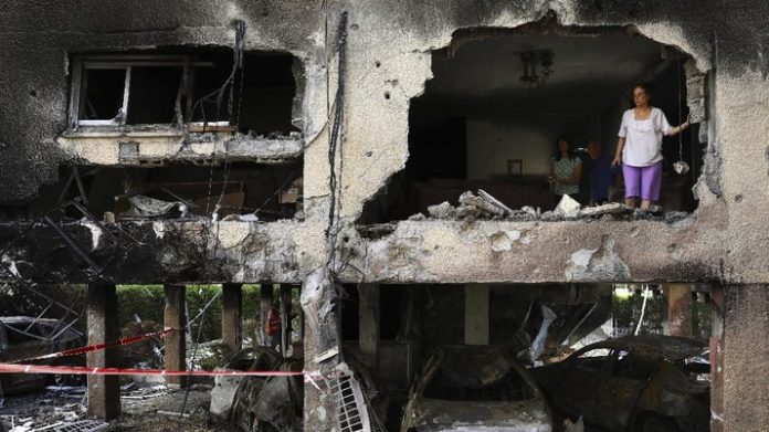 Warga memeriksa kerusakan apartemen miliknya setelah terkena roket yang ditembakkan dari Jalur Gaza pada malam hari di Petah Tikva, Israel tengah, Kamis, 13 Mei 2021. (AP Photo / Oded Balilty)