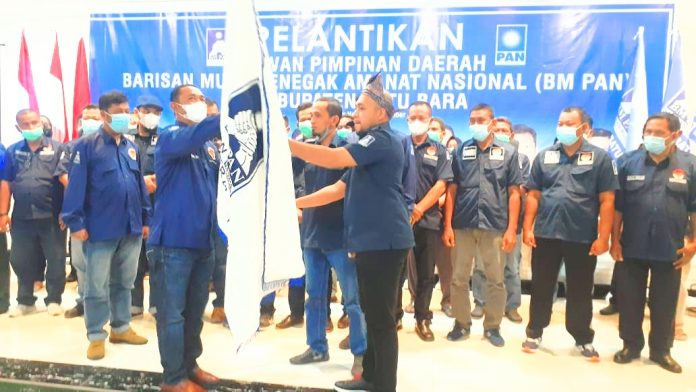 Ketua DPW BM PAN Sumut Mora Harahap menyerahkan Pataka BM PAN kepada Ketua DPD BM PAN Batu Bara Fahmi sebagai tanda pelantikan BM PAN Batu Bara periode 2021-2026.(f:ist/mistar)