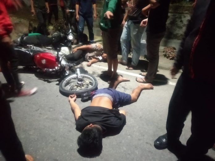 Dua pengendara sepeda motor tampak terkapar di aspal setelah kecelakaan lalu lintas di Jalan Medan, Kecamatan Siantar martoba, Kota Pematangsiantar, Kamis (31/3/22) malam. (f:daniel/mistar)