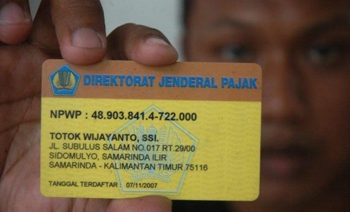Ilustrasi - Seorang wajib pajak memegang kartu No Pokok Wajib Pajak (NPWP) sistem online di Jakarta, Selasa (30/12). (FOTO ANTARA/Jefri Aries/ss/mes)