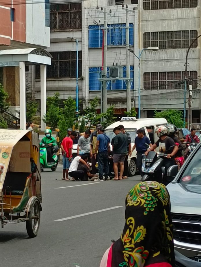 Warga memberikan pertolongan kepada personel Polda Sumut ditabrak angkot di Jalan Cirebon Medan, Selasa (4/4/2023) siang. (f:ist/mistar)