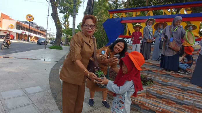 Sekolah Alam Siantar melakukan giat membagikan bibit sayur buncis dan kangkung di Lapangan Merdeka. (f:Yetty/mistar)