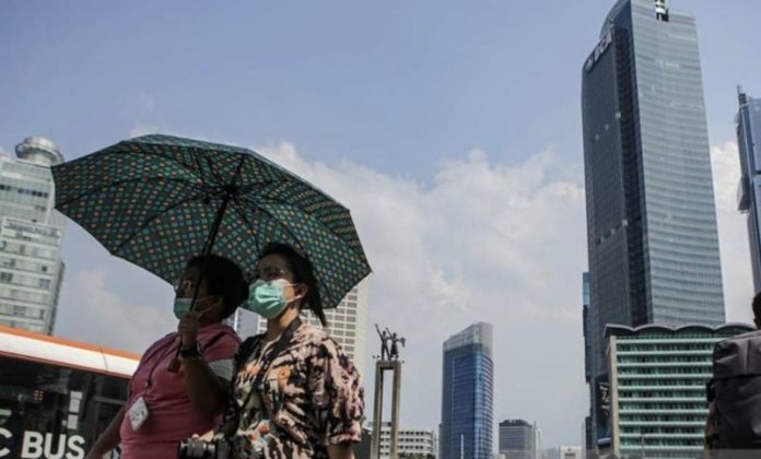 Warga berjalan di tengah cuaca terik di kawasan Bundaran HI, Jakarta, Senin (24/4/2023). Badan Meteorologi Klimatologi dan Geofisika (BMKG) menyampaikan dinamika atmosfer yang tidak biasa menjadi salah satu penyebab Indonesia mengalami suhu panas dalam beberapa hari terakhir. (ANTARA FOTO/Fauzan/nym).