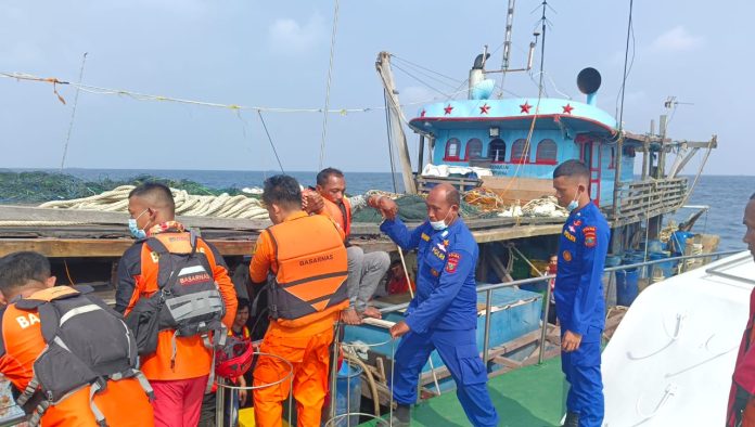 Petugas Basarnas Medan sedang mengevakuasi korban kapal tenggelam ke kapal Basarnas. (f:ist/mistar)