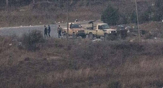 Israel, menunjukkan orang-orang bersenjata, dilaporkan kelompok pemberontak, berdiri dekat kendaraan di sisi lain Golan yang dikuasai Suriah di dekat pintu perlintasan batas Quneitra. (AFP)