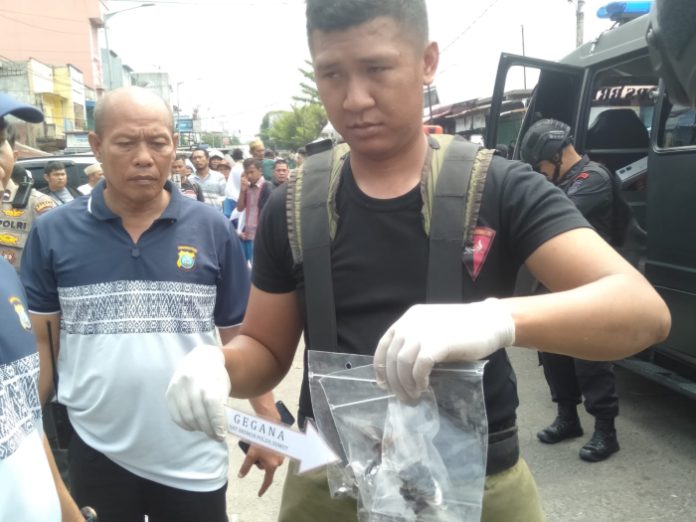 Polisi memegang benda yang diduga bom.jpg