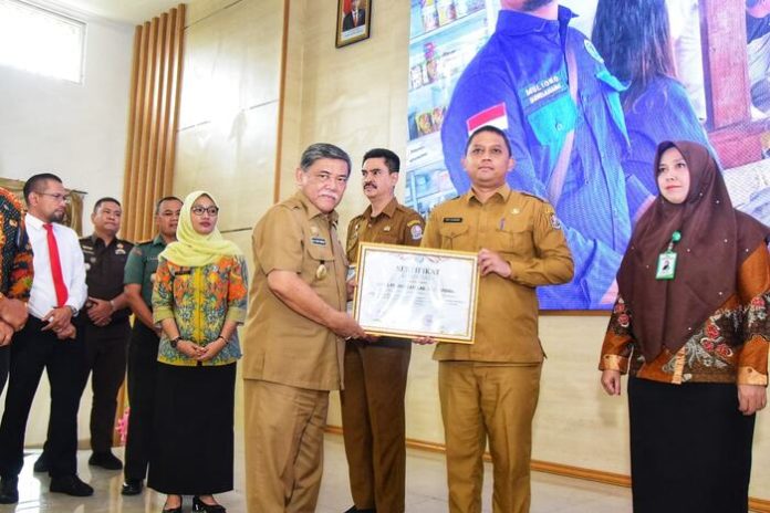 Wabup Deli Serdang, HM Ali Yusuf Siregar menyerahkan piagam penghargaan kepada Kadis Pendidikan,Yudy Hilmawan pada Puncak Peringatan HANI 2023 di Aula Cendana, Lantai II, Kantor Bupati Deli Serdang. (f:rinaldi/mistar)