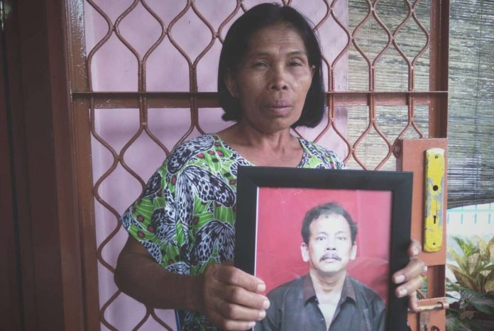 Rosmaida Panjaitan (60) menunjukan foto suaminya yang jadi korban.