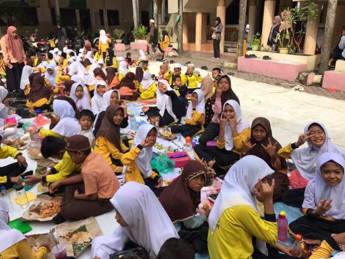Siswa SD Muhammadiyah 1 Kisaran sarapan bersama di lapangan sebab tak gelar wisuda untuk acara pelepasan. (f;ist/mistar)