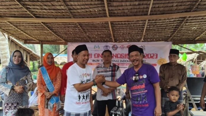 Ketua LPA Kabupaten Deli Serdang Junaidi Malik (kanan) pada Peringatan HAN 2023 di wisata jajanan Pasar Kamu Pantai Labu.
