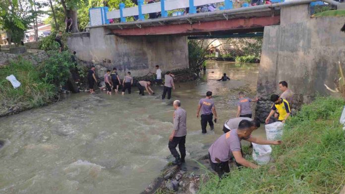 Personel Kepolisian membersihkan sampah dari aliran Sungai Malinda Lubuk Pakam.