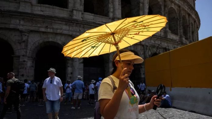 Warga di Roma menggunakan payung hindari panas yang mencapai 45 derajat celsius.